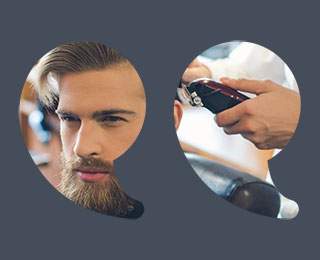 Young man with stylish hair and a full groomed beard in a salon with a stylist holding clippers behind him