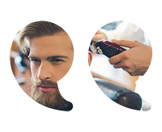 Young man with stylish hair and a full groomed beard in a salon with a stylist holding clippers behind him